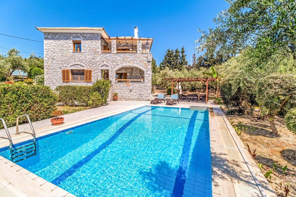 a villa with a swimming pool in front of a house at Villa Meli in Methoni