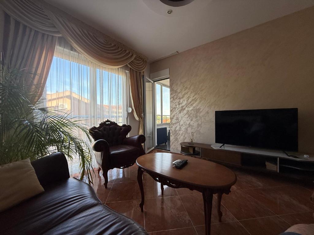 a living room with a couch and a flat screen tv at Casa Verde LLS in Budva