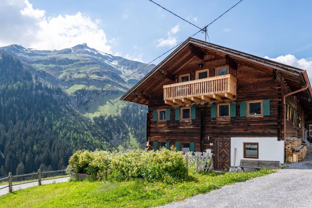drewniany dom na wzgórzu z górami w tle w obiekcie BERGCHALET VALLUGA w mieście Steeg