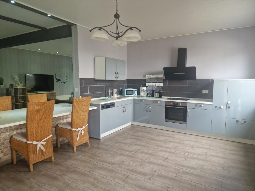 a kitchen with blue cabinets and a table and chairs at Küstenliebe 2 in Bremerhaven