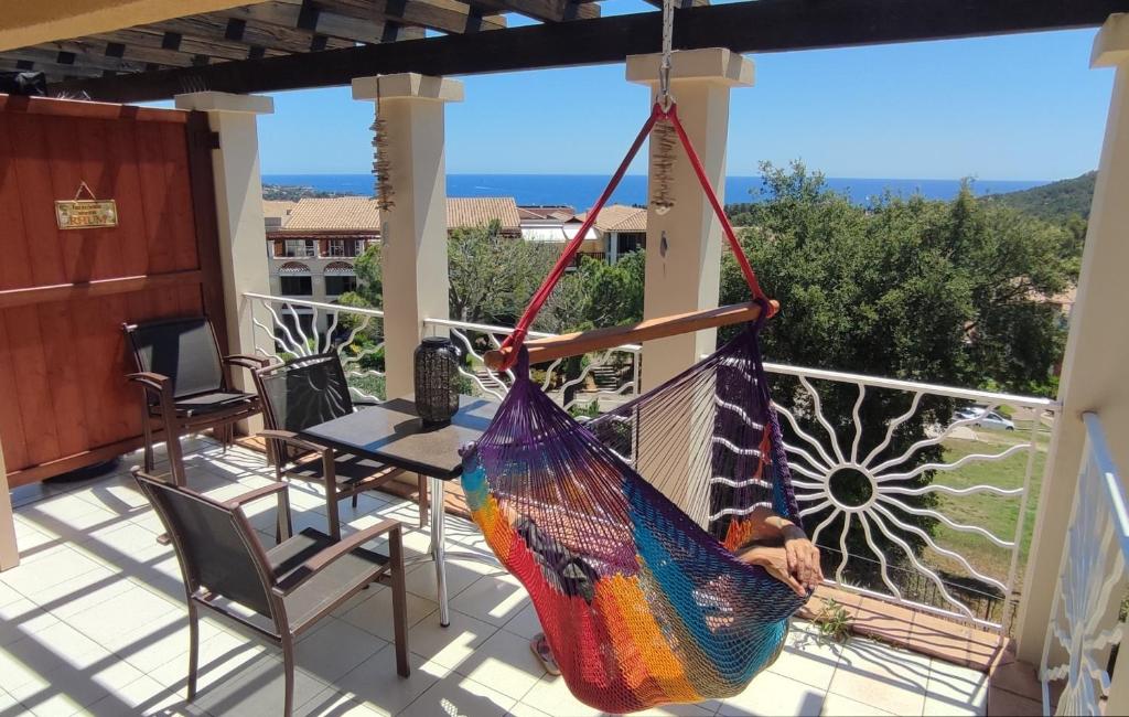 - un hamac sur un balcon avec une table et des chaises dans l'établissement Studio Vue Mer et Estérel Au Petit Paradis-Terrasse 16 m2-Cap Estérel-Saint Raphaël, à Saint-Raphaël