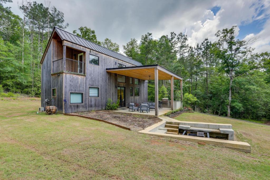 Burkevilleにある65 Acres Secluded Avian Acres Cabin with Trails!の森の中にあるパティオ付きの納屋風の家