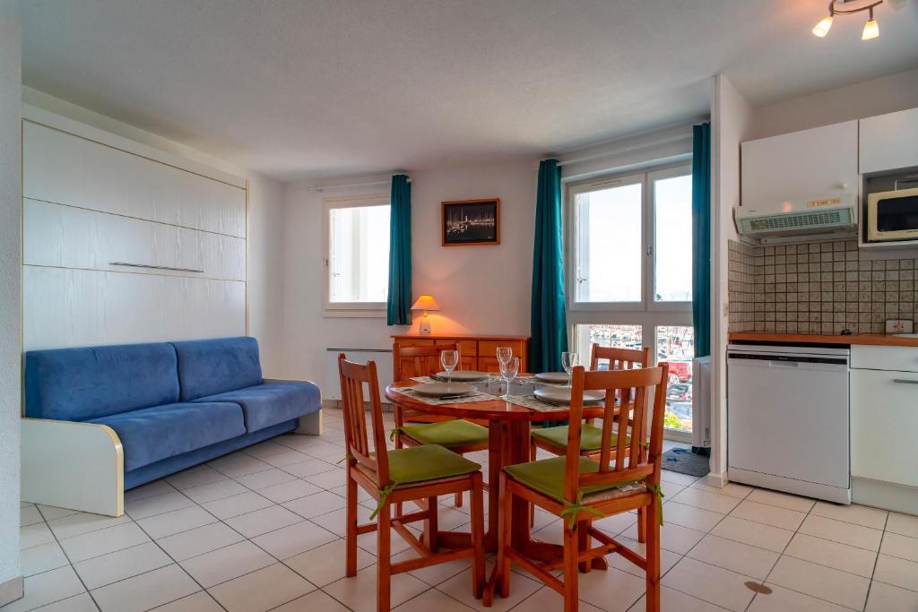 un salon avec une table, des chaises et un canapé dans l'établissement Le 47°N Crouesty - appt proche de la plage, à Arzon