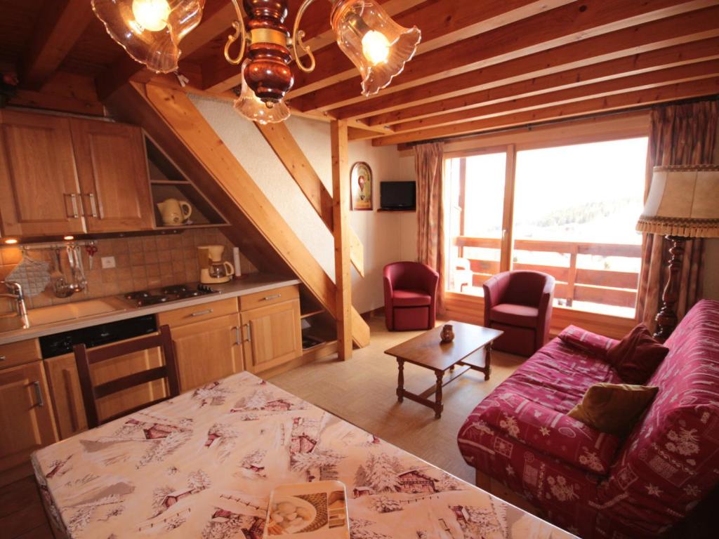 Il dispose d'une cuisine et d'un salon avec un canapé et une table. dans l'établissement Les Saisies, Apt 3 pièces/mezzanine, 2 SDB, 8 pers - FR-1-293-58, aux Saisies