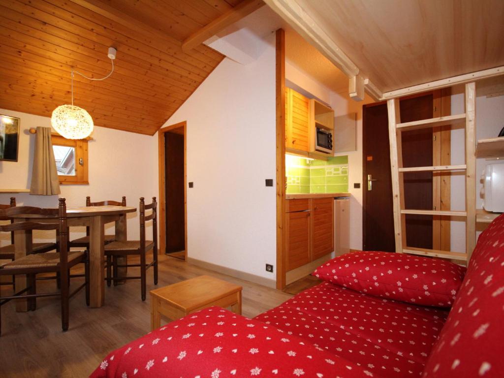 un salon avec un canapé rouge et une table dans l'établissement Charmant studio aux Saisies, 2 pers, rénové, proche pistes et commerces - FR-1-293-185, aux Saisies