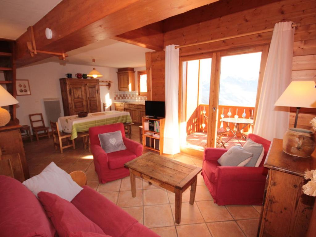 a living room with a red couch and a table at Appartement 4 pièces mezzanine avec balcon, équipements complets, animaux admis, parking couvert. - FR-1-293-64 in Villard-sur-Doron