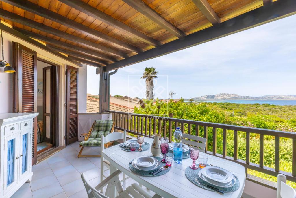a dining table on a balcony with a view of the ocean at Terrazza Celeste in Stintino