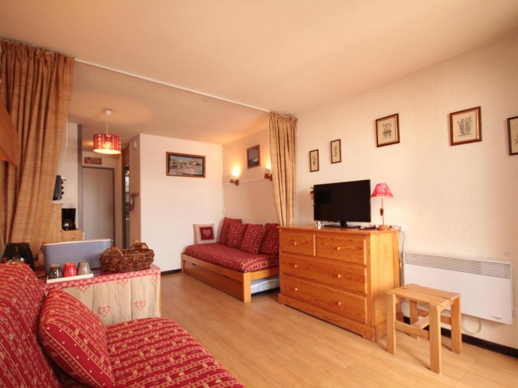 un salon avec un canapé et une télévision dans l'établissement Studio ensoleillé, équipé avec balcon au cœur des Saisies, animaux acceptés - FR-1-293-186, aux Saisies