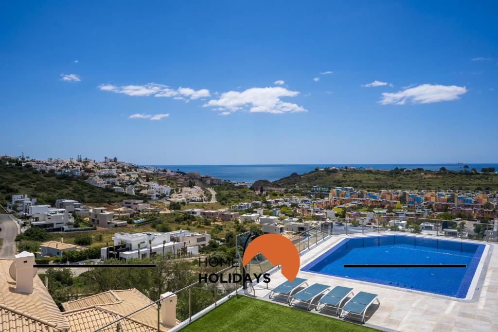 a villa with a swimming pool and a view of a city at #312 Ocean Outlook by Home Holidays in Páteo