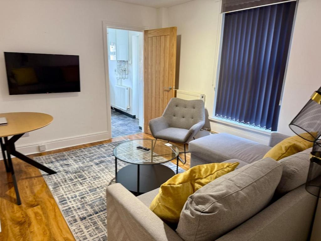 a living room with a couch and a chair at Beautiful City Centre Apartment With Garden in Cardiff