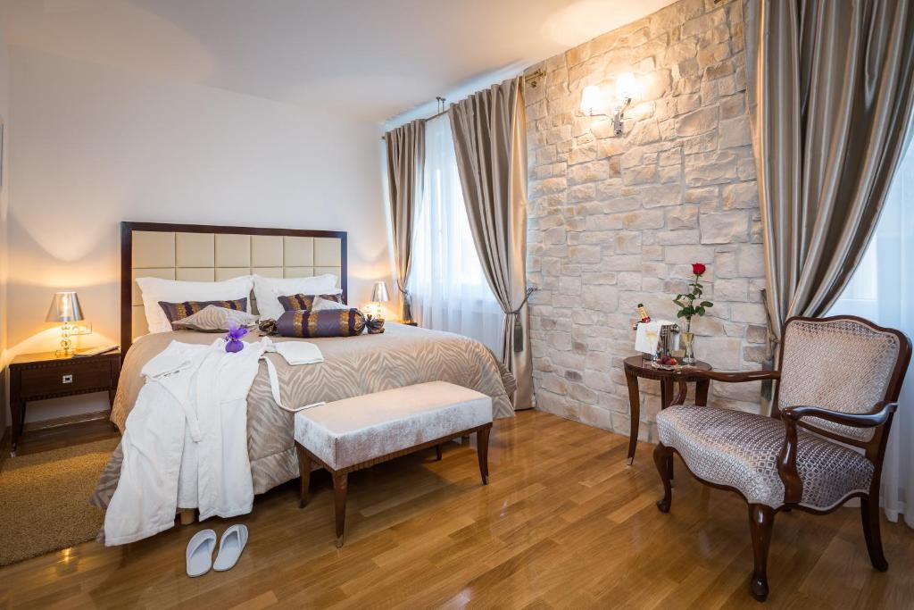1 dormitorio con 1 cama grande y pared de piedra en Priska Heritage Rooms, en Split