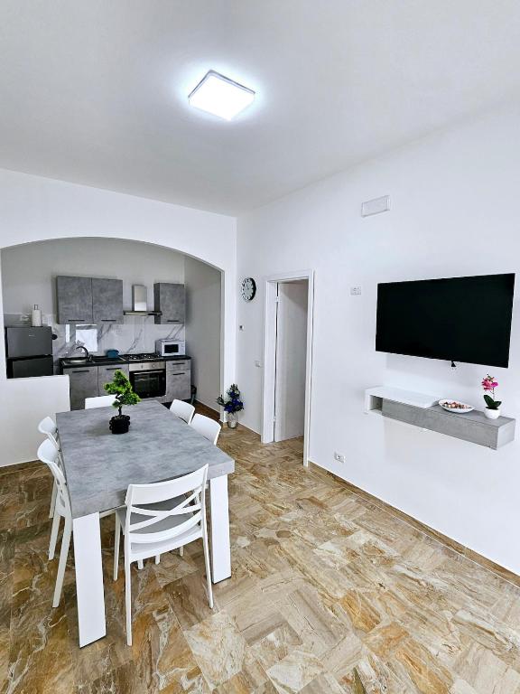 a dining room with a table and a tv on a wall at Casa vacanze Stella in Silvi Marina