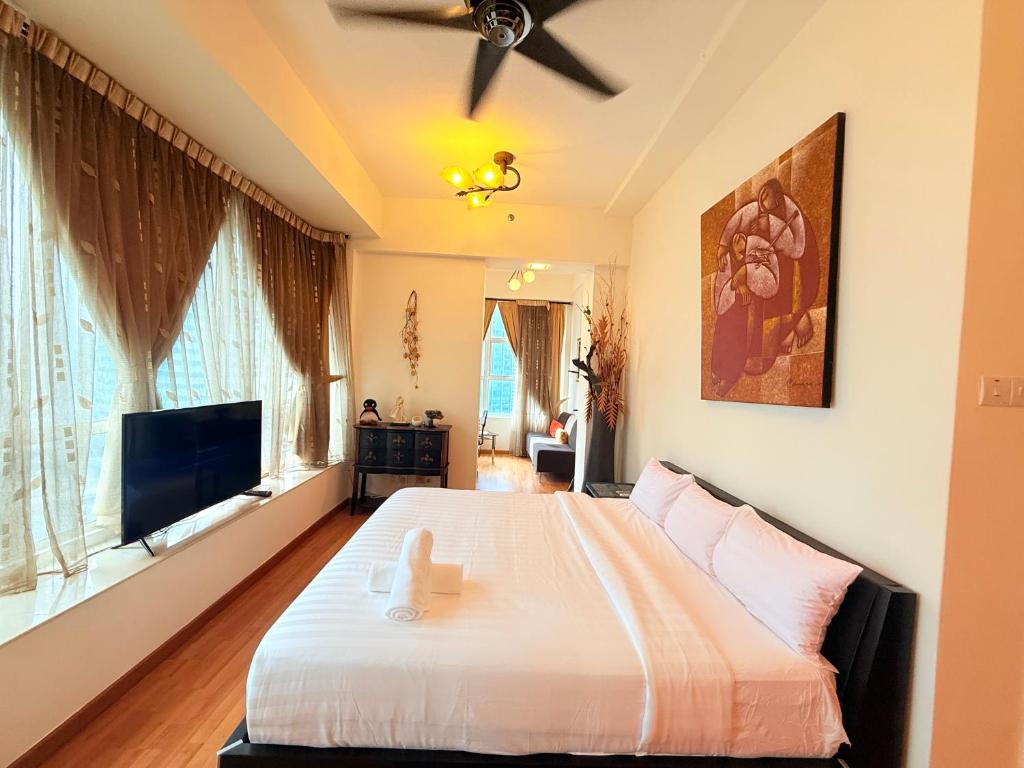 a bedroom with a bed and a flat screen tv at Park View Service Apartment By Kualalampur in Kuala Lumpur