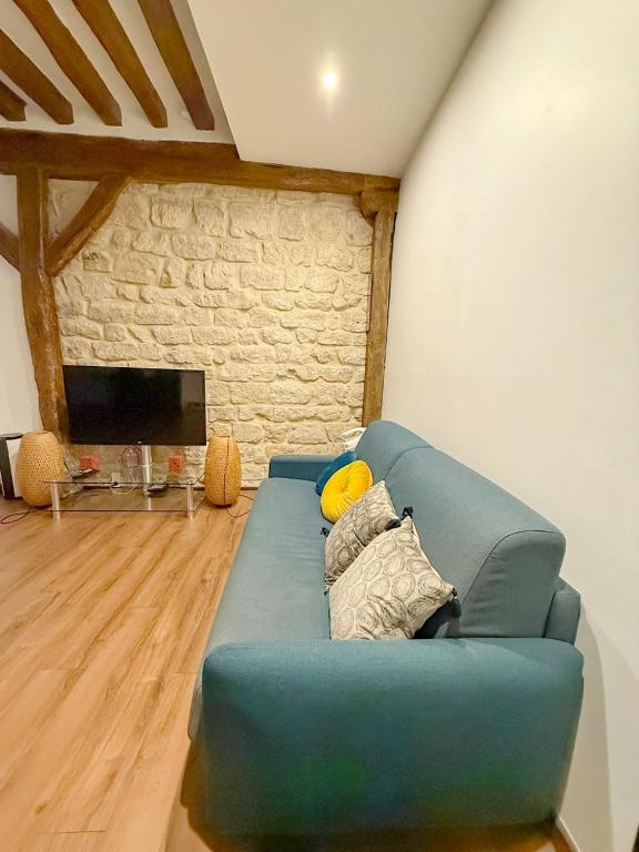 un canapé bleu dans un salon avec une télévision dans l'établissement Appartement 1 Salon et 1 Chambre Proche Notre Dame Paris 5 Centre Paris, à Paris