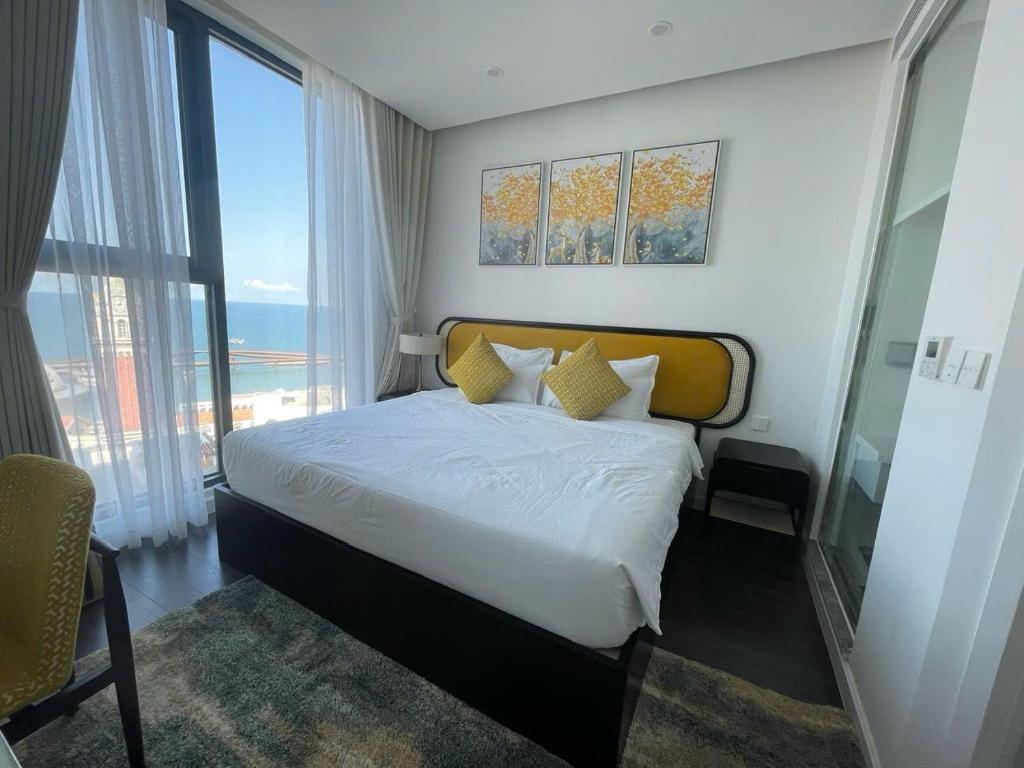 a hotel room with a bed and a large window at The Hillside Seaview Apartment Phu Quoc in Phu Quoc