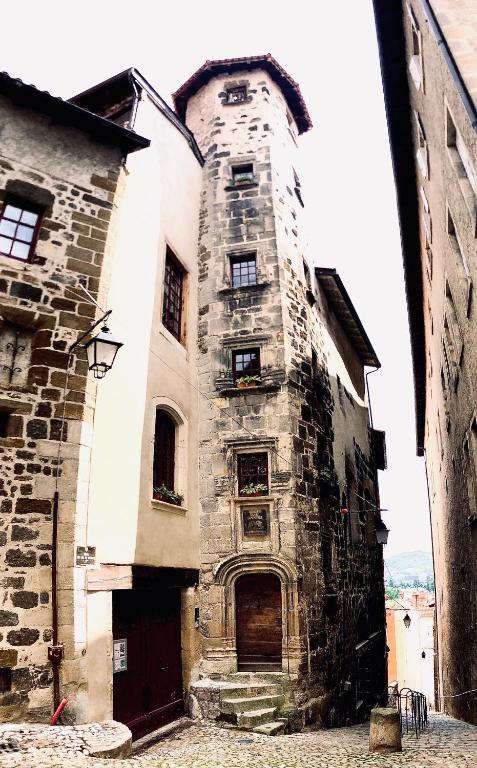- un vieux bâtiment en pierre avec une porte dans une rue dans l'établissement Appartement ciel de fugeres, au Puy-en-Velay