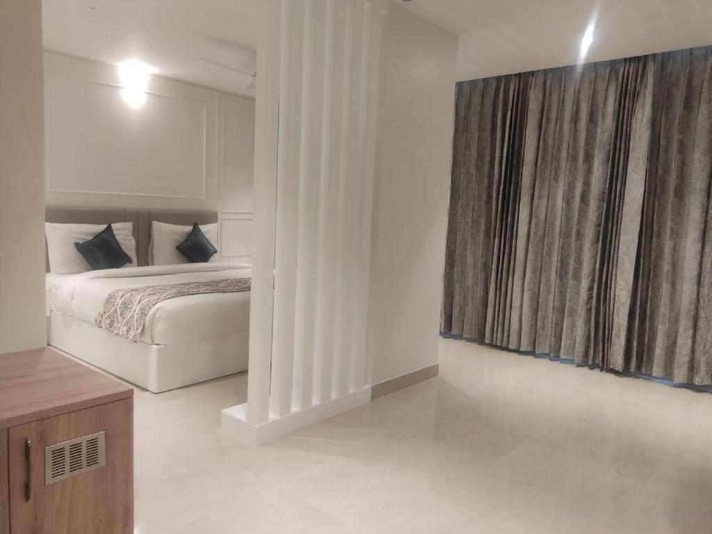 une chambre avec un lit et une grande fenêtre dans l'établissement Mumbai House Express, à Udaipur