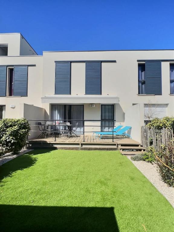 une maison avec une pelouse devant dans l'établissement Confortable pavillon climatisé à 500m de la mer, à Sérignan