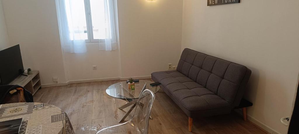 un salon avec un canapé et une table en verre dans l'établissement Sympathique 3 pièces, à Antibes
