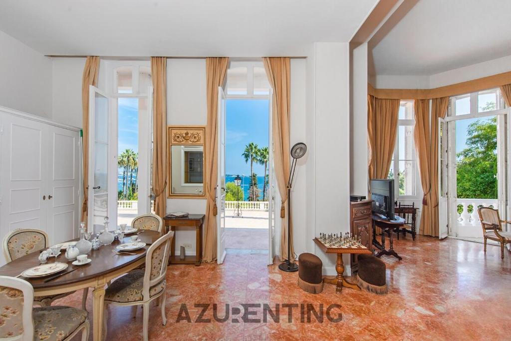 un grand salon avec une table et des chaises dans l'établissement Château de l 'Aube - AzuRenting Conciergerie, à Vallauris