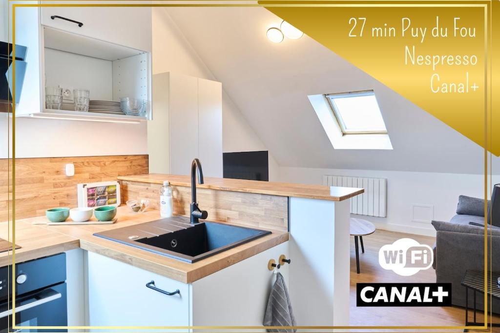 une cuisine avec un évier et un plan de travail dans l'établissement Le Carré du Mouchoir - Authentique et Fonctionnel, à Cholet