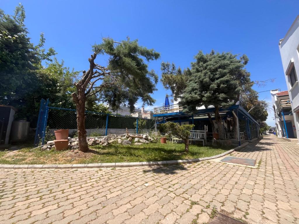 a cobblestone street with two trees and a building at Ennis İnn Resort Hotel in Marmaraereglisi