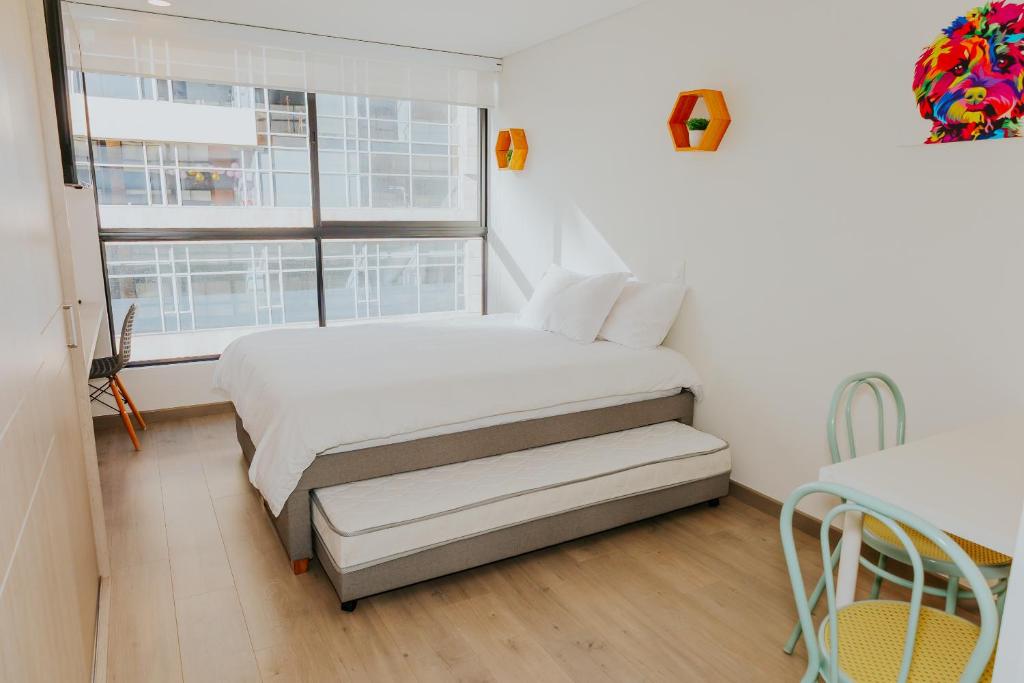 ein weißes Schlafzimmer mit einem Bett und einem Fenster in der Unterkunft Estudio en Usaquén cerca a la Fundación Santa Fe ! in Bogotá