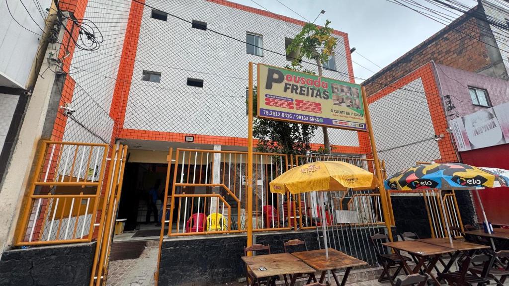 a restaurant with tables and umbrellas in front of a building at Pousada Freitas in Feira de Santana