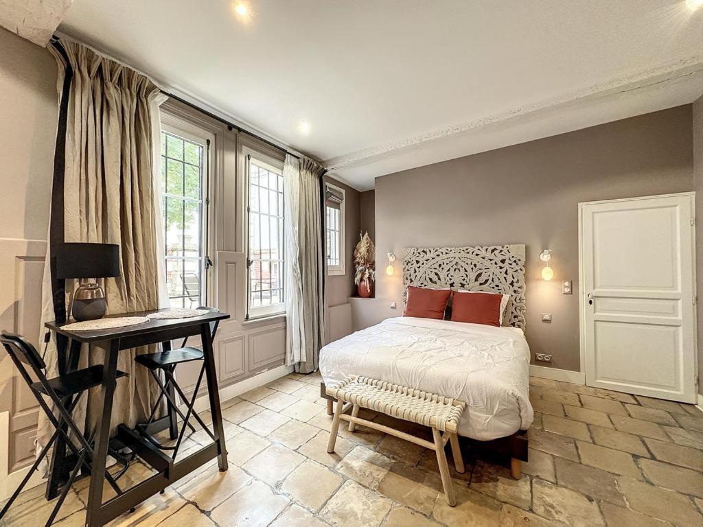a bedroom with a bed and a desk and window at Le Clos Guivet in Troyes