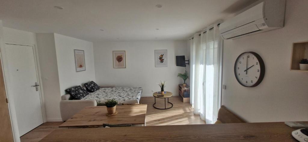 un salon avec une horloge au mur dans l'établissement studio entièrement rénové a 2 min de la mer, à Saint-Raphaël