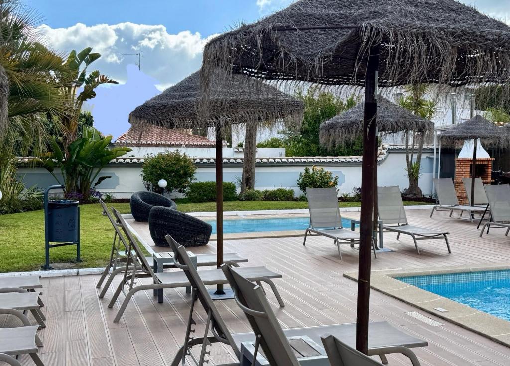 - une piscine avec des chaises et un parasol dans l'établissement Apartment Lindamar, à Lagos