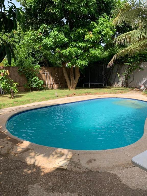 a small blue swimming pool in a yard at Soleil ak Jàmm in Mbour