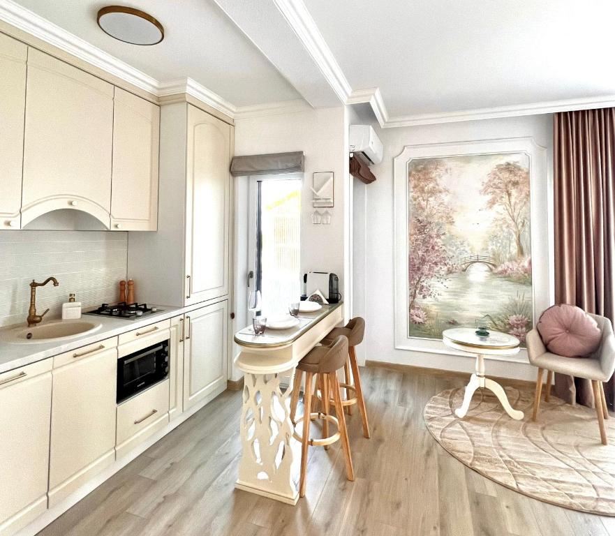 eine Küche mit weißen Schränken und einem Tisch und Stühlen in der Unterkunft Bridge Apartments- STUDIO 3 in Besenic