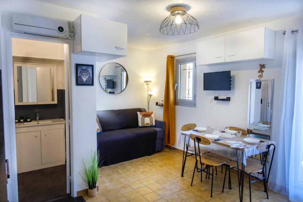 Il comprend un salon et une cuisine avec une table et un canapé. dans l'établissement Studio with balcony 50 m from the beach, à Sainte-Maxime