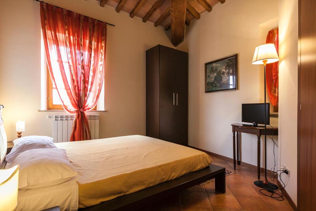 - une chambre avec un grand lit et une fenêtre dans l'établissement Il Conte Matto, à Trequanda