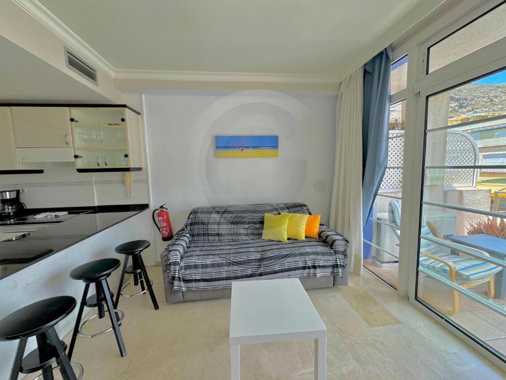Un pequeño dormitorio con una cama y una cocina. en Mogán harbor apartment, en Puerto de Mogán