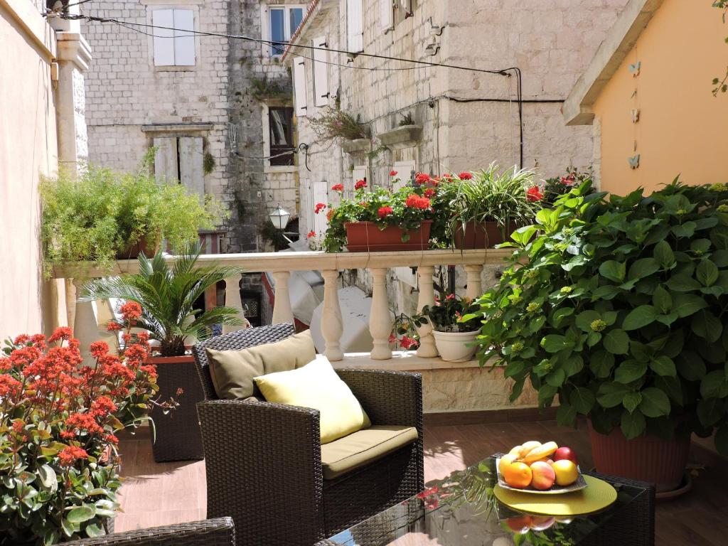 Apartments & Rooms Trogir Stars FREE PARKING في تروغير: بلكونه فيها نباتات وطاولة فيها صحن فواكه