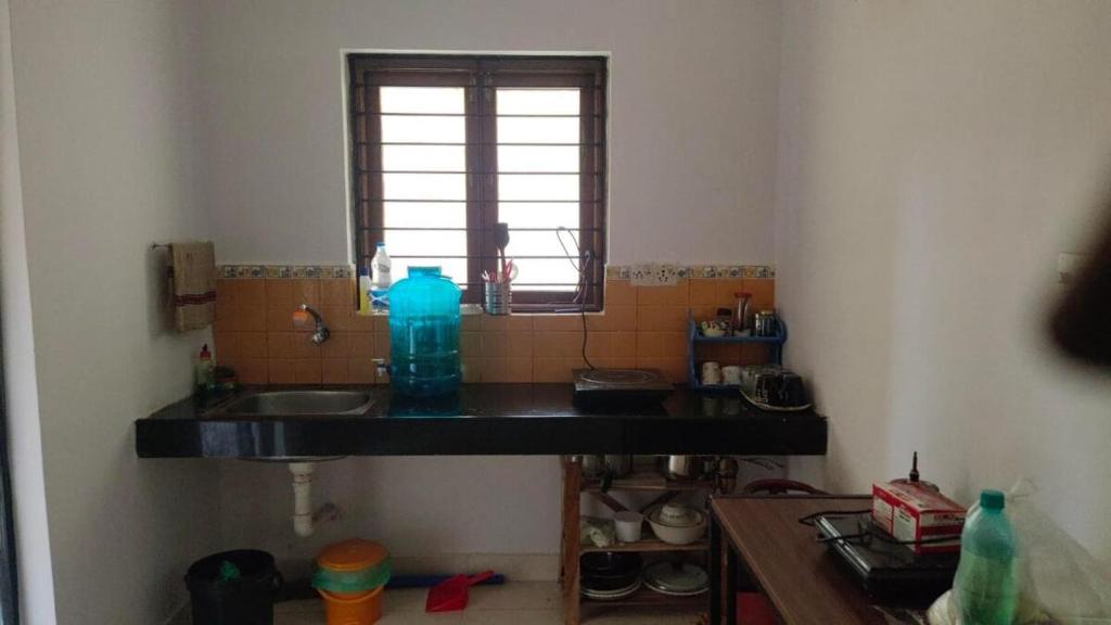a bathroom with a sink and a window at Palms Cosy affordable homely flat in Arpora
