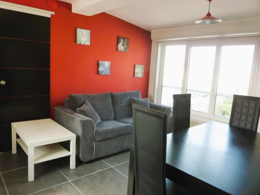 un salon avec un canapé et une table dans l'établissement Appartement front de mer Biarritz, à Biarritz