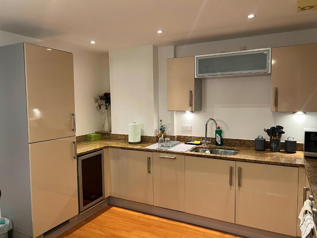 a kitchen with white cabinets and a sink at Marina Breeze in Swansea