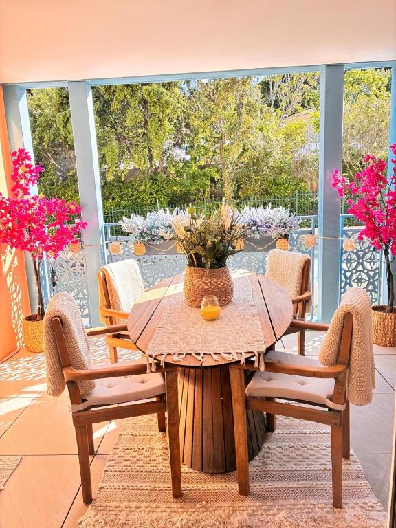 une table et des chaises sur une terrasse ornée de fleurs roses dans l'établissement Le Bougainvillier, à Cavalaire-sur-Mer