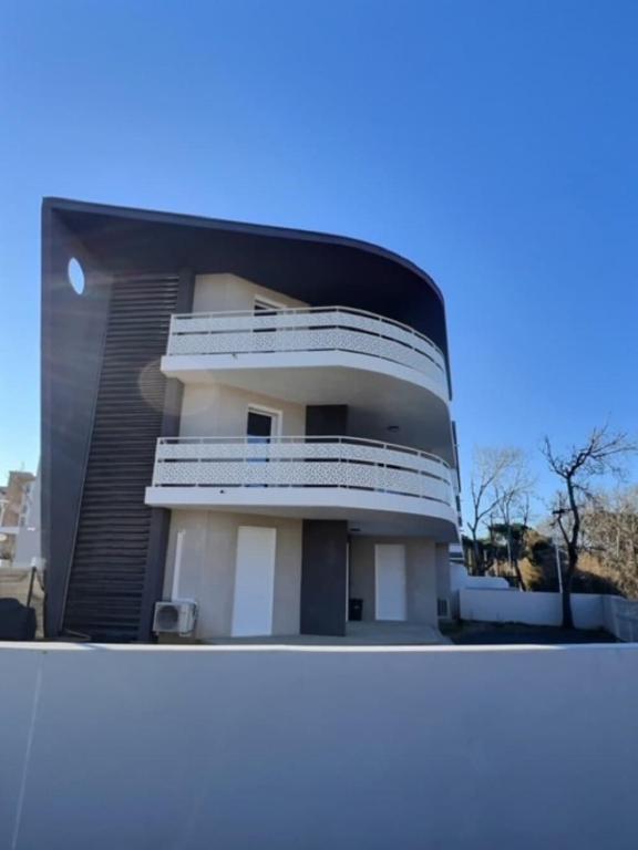 un bâtiment avec des balcons sur le côté dans l'établissement Agréable appartement pour 4 personnes à 150m de la plage, à Vias