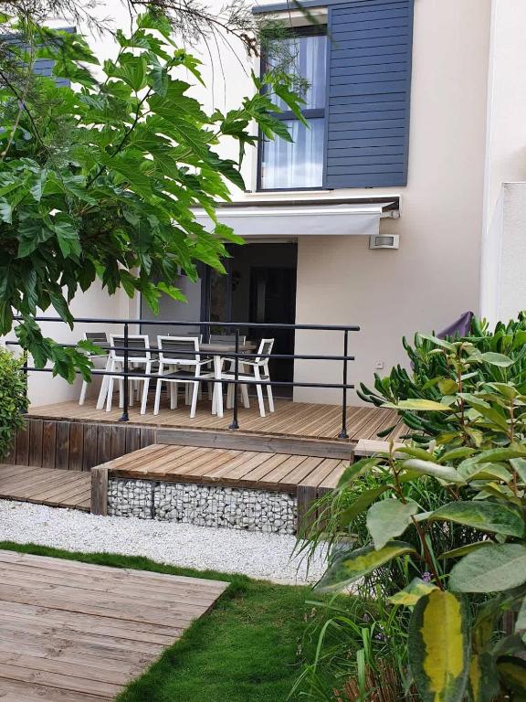une terrasse en bois avec une table et des chaises dessus dans l'établissement A 500m de la plage, pavillon confortable 6 personnes dans résidence recente, à Valras-Plage