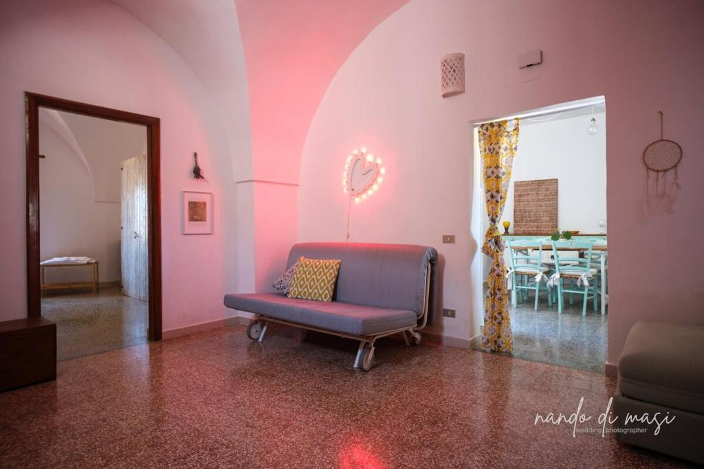 a living room with a chair and a table at Masseria Giangrande - Rooms and Apartment in Polignano a Mare
