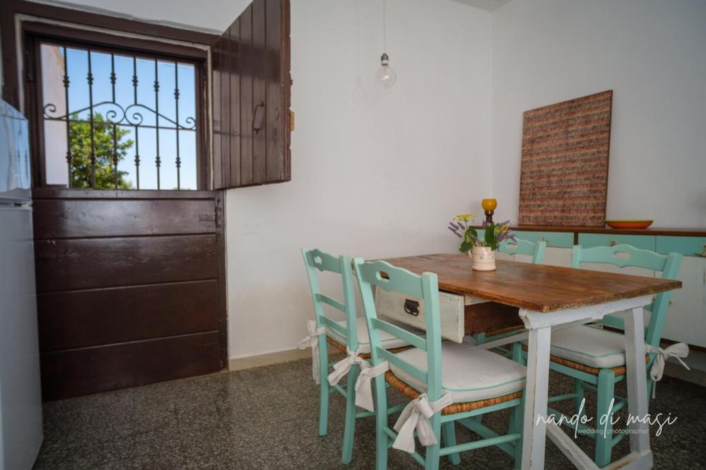 a kitchen with a wooden table and chairs at Masseria Giangrande - Rooms and Apartment in Polignano a Mare