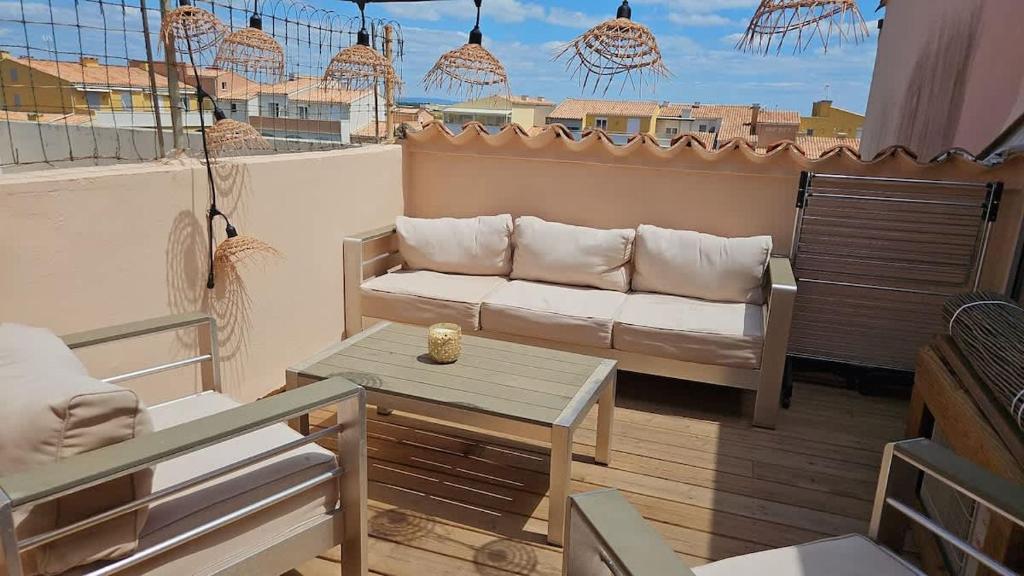 - un salon avec un canapé et une table sur un balcon dans l'établissement Agde-Loc Cap 68, au Cap d'Agde