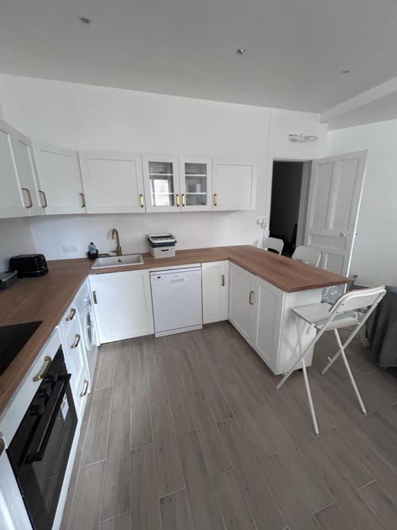 une cuisine avec des armoires blanches et un comptoir en bois dans l'établissement Appart tout confort, à Marseille