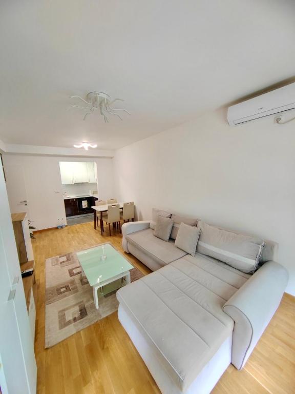 a living room with a white couch and a table at Safari Apartment in Petrovaradin
