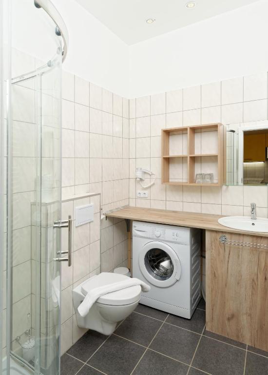 W łazience znajduje się toaleta, umywalka i pralka. w obiekcie Apartments Villa Luna w Wiedniu