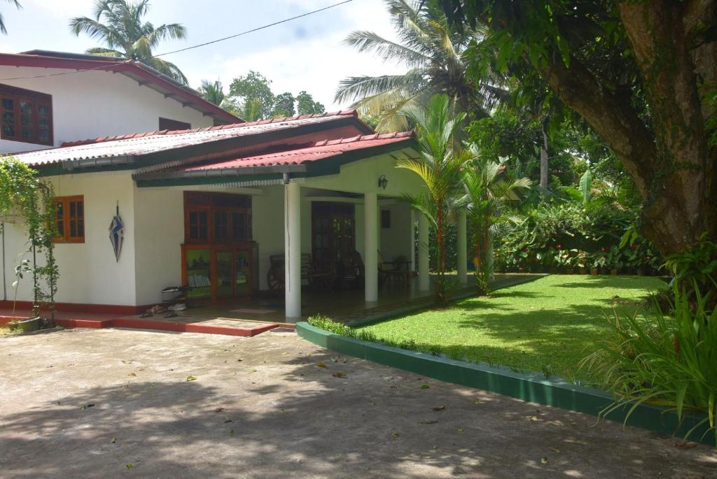 a house with a green lawn in front of it at CFC Holiday Home in Anuradhapura